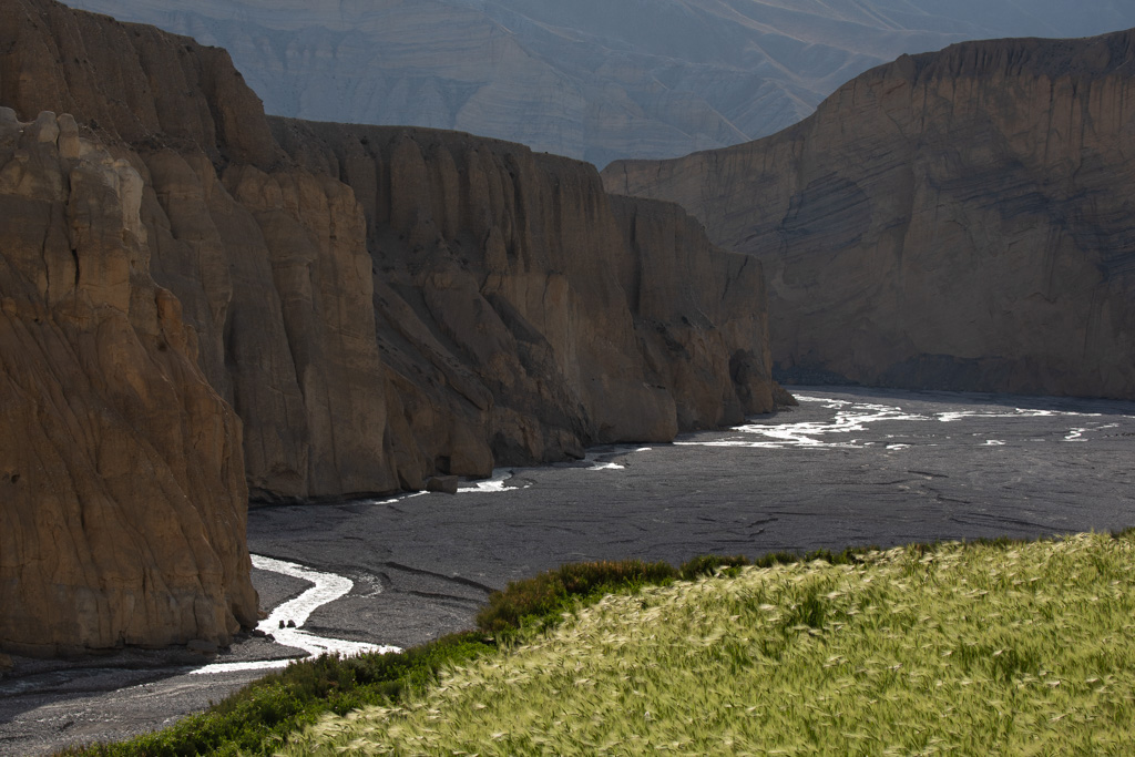a landscape that looks like a dry riverbed surrounded by overhanging mountains